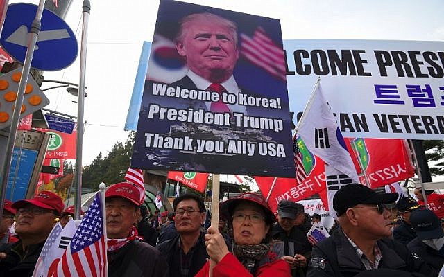 A file photo taken on November 8, 2017 shows pro-Trump supporters holding a placard with a picture of US President Donald Trump as they wait for Trump outside the National Cemetery in Seoul. (AFP Photo/Jung Yeon-je) A file photo taken on November 8, 2017 shows pro-Trump supporters holding a placard with a picture of US President Donald Trump as they wait for Trump outside the National Cemetery in Seoul. (AFP Photo/Jung Yeon-je)