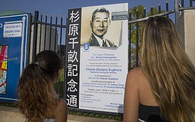 This photo taken on June 7, 2016 shows people looking at a placard following an inauguration ceremony for a street named after Japanese diplomat Chiune Sugihara, in the Israeli coastal city of Netanya. (AFP PHOTO / JACK GUEZ)