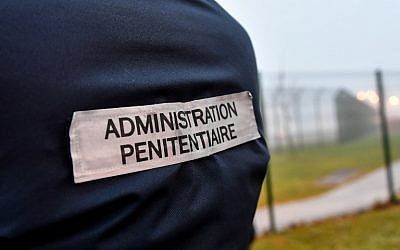 The penitentiaty administration tag is pictured on a warden's jacket as prison wardens gather outside the high-security prison of Vendin-le-Vieil, northern France, on January 12, 2018, a day after three prison guards have been injured in a blade attack by a German Al-Qaeda terrorist. (AFP PHOTO / Denis Charlet)