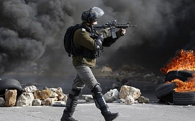 An Israeli border policeman takes position during clashes with Palestinians protestors on January 12, 2018 north of Ramallah in the West Bank. (AFP PHOTO / ABBAS MOMANI)