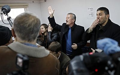 Bassem Tamimi (C) the father of sixteen-year-old Palestinian Ahed Tamimi (UNSEEN), a well-known campaigner against Israel's occupation, waves at his daughter during a hearing in the Israeli military court at Ofer military prison in the West Bank village of Betunia on January 15, 2018. (Thomas Coex/AFP)
