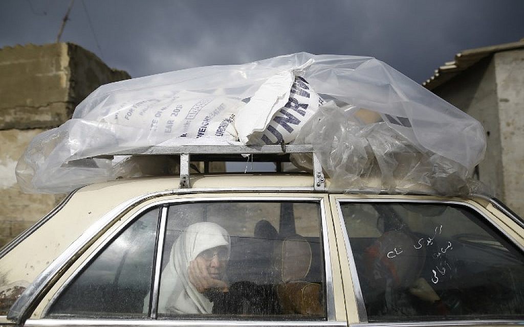A Palestinian woman rides in a car after collecting aid provided by the UN agency for Palestinian refugees UNRWA, in Gaza City on January 17, 2018. (AFP/Mohammed Abed)