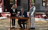 Prime Minister Benjamin Netanyahu (C) signs a visitors book as his wife Sara Netanyahu (L) and Indian Prime Minister Narendra Modi look on during a visit to the Gandhi Ashram in Ahmedabad on January 17, 2018. (AFP Photo/Sam Panthaky)