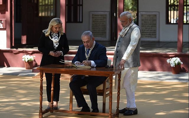 Prime Minister Benjamin Netanyahu (C) signs a visitors book as his wife Sara Netanyahu (L) and Indian Prime Minister Narendra Modi look on during a visit to the Gandhi Ashram in Ahmedabad on January 17, 2018. (AFP Photo/Sam Panthaky) Prime Minister Benjamin Netanyahu (C) signs a visitors book as his wife Sara Netanyahu (L) and Indian Prime Minister Narendra Modi look on during a visit to the Gandhi Ashram in Ahmedabad on January 17, 2018. (AFP Photo/Sam Panthaky)