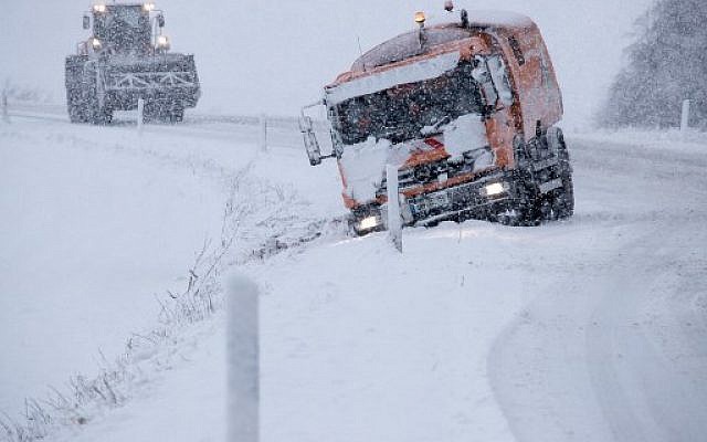 A wheel loader approaches a truck that has slipped off the track due to heavy snowfall on January 18, 2018 near Bruesewitz, northeastern Germany. (AFP Photo/dpa/Jens Büttner/Germany OUT) A wheel loader approaches a truck that has slipped off the track due to heavy snowfall on January 18, 2018 near Bruesewitz, northeastern Germany. (AFP Photo/dpa/Jens Büttner/Germany OUT)