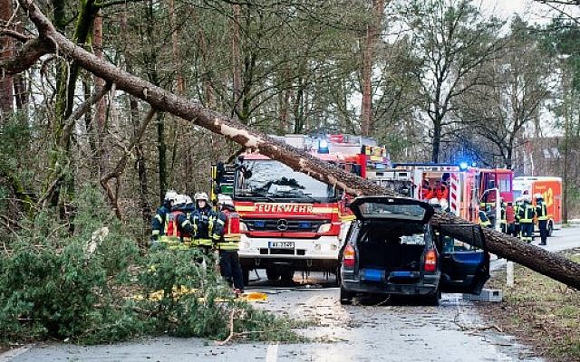 Firefighters and rescue teams stand next to a car on which a tree fell due to heavy storms on January 18, 2018 in Bielefeld, western Germany. (AFP Photo/dpa/Christian Mathiesen/Germany OUT) Firefighters and rescue teams stand next to a car on which a tree fell due to heavy storms on January 18, 2018 in Bielefeld, western Germany. (AFP Photo/dpa/Christian Mathiesen/Germany OUT)