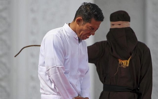 Jono Simbolon (front), an Indonesian Christian, grimaces in pain as he is flogged in front of a crowd outside a mosque in Banda Aceh, Aceh province, on January 19, 2018. (AFP PHOTO / CHAIDEER MAHYUDDIN) Jono Simbolon (front), an Indonesian Christian, grimaces in pain as he is flogged in front of a crowd outside a mosque in Banda Aceh, Aceh province, on January 19, 2018. (AFP PHOTO / CHAIDEER MAHYUDDIN)