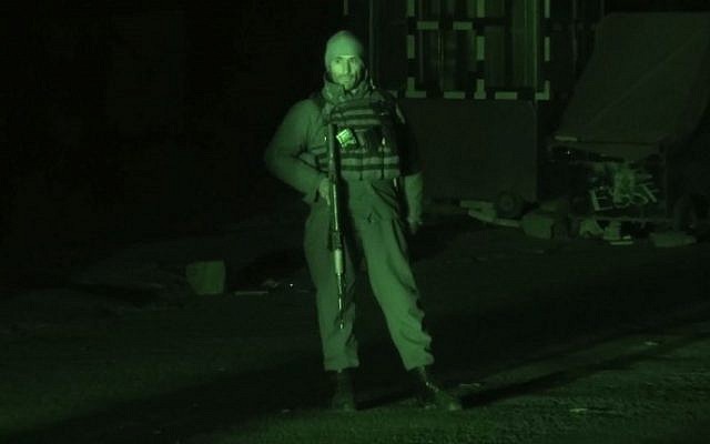 This screengrab made from an AFP video taken on January 20, 2018 with the aid of a nightvision camera, show a member of security forces standing guard in the vicinity of the Intercontinental hotel in Kabul. (AFP PHOTO / AFPTV / Nasrullah ATTAR)