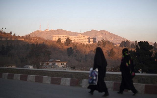 Two Afghan women walk past the Intercontinental Hotel after an attack in Kabul on January 21, 2018 (AFP PHOTO / SHAH MARAI)