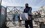 Palestinian refugees collect aid parcels at a United Nations food distribution center in Rafah in the southern Gaza Strip on January 21, 2018. (AFP/Said Khatib)