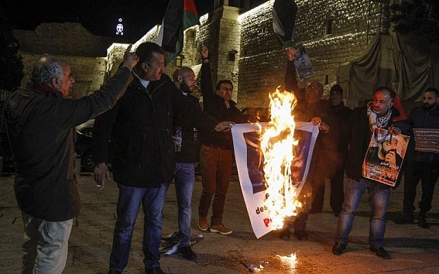 Palestinian protesters burn posters bearing portraits of US Vice President Mike Pence during a demonstration at the Manger Square in the town of Bethlehem in the occupied West Bank, on January 21, 2018. (AFP/ Musa AL SHAER)