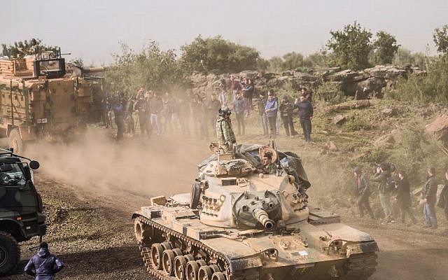 Syrian opposition fighters drive past Turkish troops in Syria near the Syrian border in Hassa, Hatay province, on January 22, 2018. (AFP PHOTO / BULENT KILIC) Syrian opposition fighters drive past Turkish troops in Syria near the Syrian border in Hassa, Hatay province, on January 22, 2018. (AFP PHOTO / BULENT KILIC)