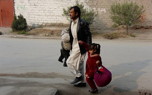 An Afghan man runs with two children near an office of the British charity Save the Children during an ongoing attack in Jalalabad on Wednesday, January 24, 2018. (AFP PHOTO/Noorullah SHIRZADA) An Afghan man runs with two children near an office of the British charity Save the Children during an ongoing attack in Jalalabad on Wednesday, January 24, 2018. (AFP PHOTO/Noorullah SHIRZADA)
