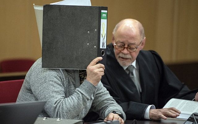 The defendant accused of a bombing at the Dusseldorf-Wehrhahn station targeting Jewish immigrants in the year 2000 hides his face behind a folder and sits next to his lawyer as he waits for the start of his trial on January 25, 2018 in Dusseldorf, western Germany. (AFP Photo/dpa/Federico Gambarini) The defendant accused of a bombing at the Dusseldorf-Wehrhahn station targeting Jewish immigrants in the year 2000 hides his face behind a folder and sits next to his lawyer as he waits for the start of his trial on January 25, 2018 in Dusseldorf, western Germany. (AFP Photo/dpa/Federico Gambarini)