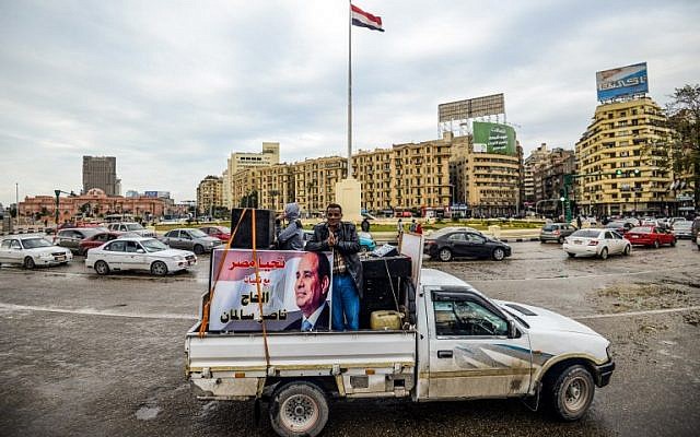 Supporters of Egyptian President Abdel Fattah al-Sissi drive a pickup truck bearing his portrait and loudspeakers, in the capital Cairo's Tahrir square on January 25, 2018. (Illustrative: AFP/ MOHAMED EL-SHAHED) Supporters of Egyptian President Abdel Fattah al-Sissi drive a pickup truck bearing his portrait and loudspeakers, in the capital Cairo's Tahrir square on January 25, 2018. (Illustrative: AFP/ MOHAMED EL-SHAHED)