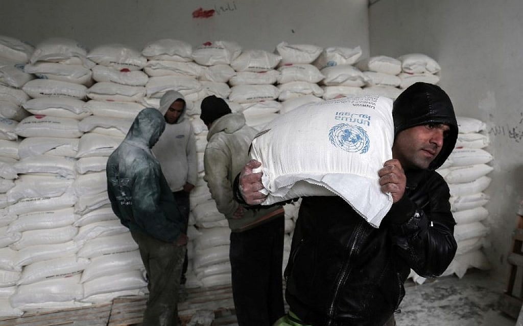 Palestinians collect food aid at a United Nations food distribution center in Khan Younis in the southern Gaza Strip on January 28, 2018. (Said Khatib/AFP)