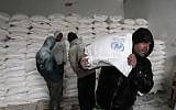 Palestinians collect food aid at a United Nations food distribution center in Khan Younis in the southern Gaza Strip on January 28, 2018. (Said Khatib/AFP)