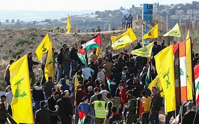 Israeli soldiers (top L) and UN peacekeepers (top R) look at Lebanese supporters of the Shiite Hezbollah movement attending a rally against the US president's decision to recognize Jerusalem as the capital of Israel, on January 28, 2018, in the southern Lebanese village of Alma al-Shaab, on the border with Israel. (AFP PHOTO / Mahmoud ZAYYAT)