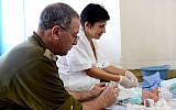 Illustrative. An IDF doctor treats a baby born with a birth defect during a humanitarian aid mission to the Philippines following a typhoon on November 18, 2013. (Israel Defense Forces/Flickr)