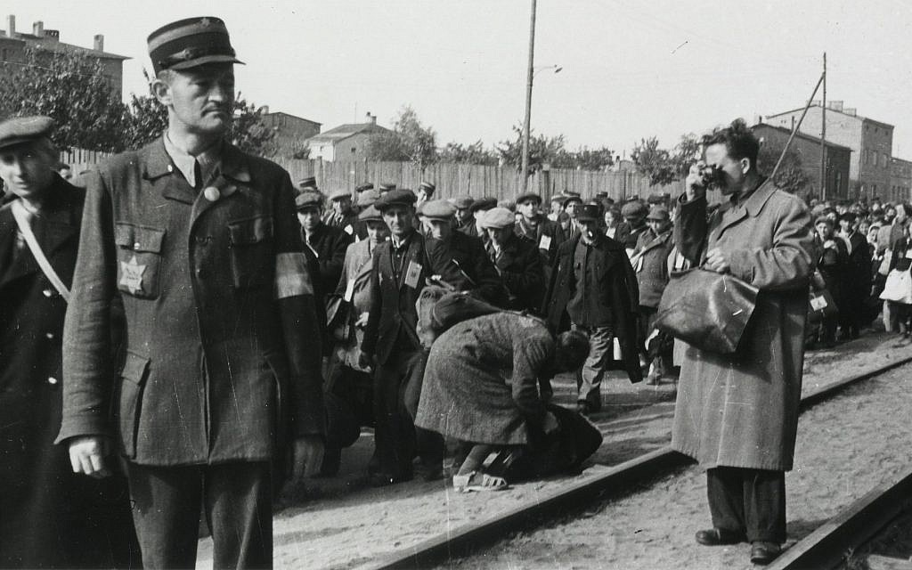 Łódź ghetto photographer Mendel Grossman clandestinely photographing the deportation of Jews. The photo was taken by Grossman’s assistant, Aryeh Ben-Menachem. (Yad Vashem Archives)