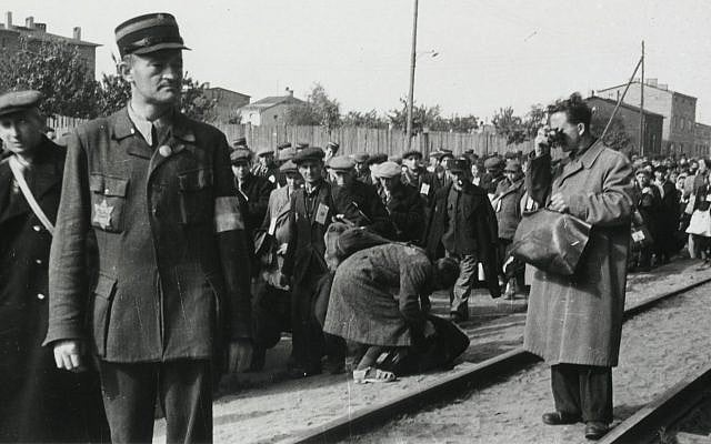 Łódź ghetto photographer Mendel Grossman clandestinely photographing the deportation of Jews. The photo was taken by Grossman’s assistant, Aryeh Ben-Menachem. (Yad Vashem Archives)