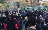 University students attend a protest inside Tehran University while a smoke grenade is thrown by anti-riot Iranian police, in Tehran, Iran, December 30, 2017. (AP Photo)