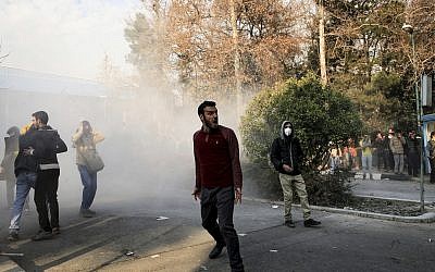 University students attend a protest inside Tehran University while a smoke grenade is thrown by anti-riot Iranian police, in Tehran, Iran, December 30, 2017. (AP Photo)