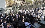 University students attend a protest inside Tehran University while a smoke grenade is thrown by Iranian anti-riot police, Tehran, Iran, December 30, 2017. (AP Photo)