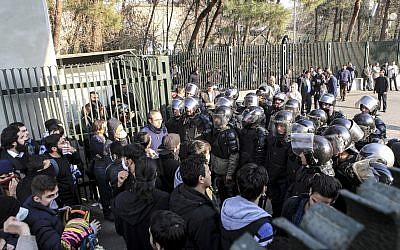 University students attend a protest inside Tehran University while a smoke grenade is thrown by Iranian anti-riot police, Tehran, Iran, December 30, 2017. (AP Photo)