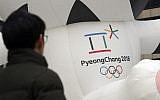 A man walks by the official emblem of the 2018 Pyeongchang Olympic Winter Games, in downtown Seoul, South Korea, December 29, 2017. (AP Photo/Lee Jin-man)