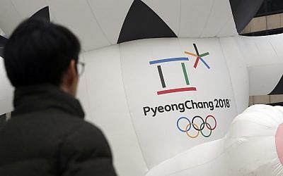 A man walks by the official emblem of the 2018 Pyeongchang Olympic Winter Games, in downtown Seoul, South Korea, December 29, 2017. (AP Photo/Lee Jin-man)