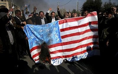 Iranian worshippers chant slogans while they burn a representation of US flag during a rally against anti-government protestors after the Friday prayer ceremony in Tehran, Iran, January 5, 2018. (AP Photo/Ebrahim Noroozi)