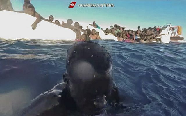 This frame of a video taken by the Italian Coast Guard on January 6, 2018, in the Mediterranean Sea off Libya, shows migrants being rescued from dinghies as they try to cross to Italy. (Italian Coast Guard via AP Photo) This frame of a video taken by the Italian Coast Guard on January 6, 2018, in the Mediterranean Sea off Libya, shows migrants being rescued from dinghies as they try to cross to Italy. (Italian Coast Guard via AP Photo)