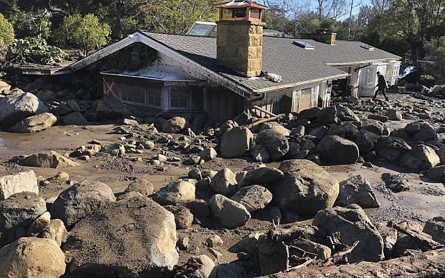 In this photo provided by Santa Barbara County Fire Department, Kerry Mann navigates the large boulders and mudflow that destroyed the home of her friend in Montecito, Calif., Wednesday, Jan. 10, 2018. The woman who lives in the home has not been seen since the early hours of Tuesday. (Mike Eliason/Santa Barbara County Fire Department via AP) In this photo provided by Santa Barbara County Fire Department, Kerry Mann navigates the large boulders and mudflow that destroyed the home of her friend in Montecito, Calif., Wednesday, Jan. 10, 2018. The woman who lives in the home has not been seen since the early hours of Tuesday. (Mike Eliason/Santa Barbara County Fire Department via AP)