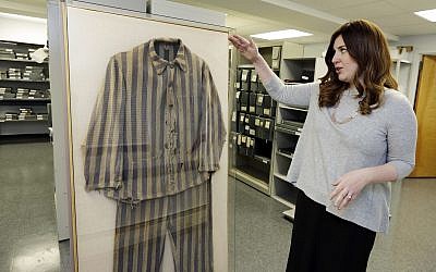 Shoshana Greenwald, director of Collections  at the Amud Aish Memorial Museum, in Brooklyn, NY, talks about the 1945 uniform of Bergen-Belsen concentration camp survivor Chaim Schmidt, in the museum's archive room, on January 10, 2018. (AP Photo/ Richard Drew)