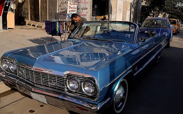In this Wednesday, January 10, 2018 photo, a man cleans a blue 1964 Chevrolet parked in front of owner Saad al-Nuaimi's coffee shop in the northern Azamiyah neighborhood of Baghdad, Iraq. (AP Photo/Khalid Mohammed) In this Wednesday, January 10, 2018 photo, a man cleans a blue 1964 Chevrolet parked in front of owner Saad al-Nuaimi's coffee shop in the northern Azamiyah neighborhood of Baghdad, Iraq. (AP Photo/Khalid Mohammed)