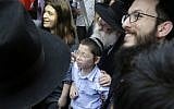 Moshe Holtzberg, center, a young boy whose parents were killed at the Chabad House in Mumbai during a 2008 terror attack, arrives with grandparents at the site of the attack on Tuesday, January 16, 2018 (AP Photo/Rajanish Kakade)