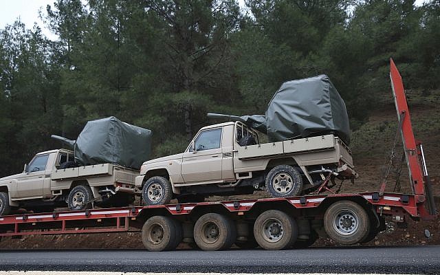 A truck, part of a convoy, carrying military pickup trucks with machine guns attached is seen on the outskirts of the village of Sugedigi, Turkey, Sunday, January 21, 2018. (AP/Lefteris Pitarakis)