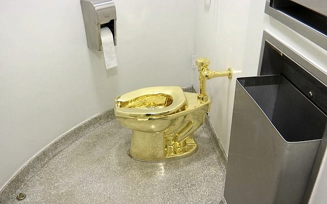An 18-karat toilet, titled "America," by Maurizio Cattelan in the restroom of the Solomon R. Guggenheim Museum in New York (screenshot) An 18-karat toilet, titled "America," by Maurizio Cattelan in the restroom of the Solomon R. Guggenheim Museum in New York (screenshot)
