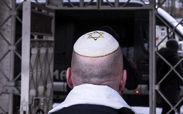 A man with a Jewish yarmulke walks in front of the camp entrance after a wreath-laying ceremony on occasion of the International Holocaust Remembrance Day in the former Nazi concentration camp Buchenwald near Weimar, Germany, Friday, Jan. 26, 2018.  (AP Photo/Jens Meyer)