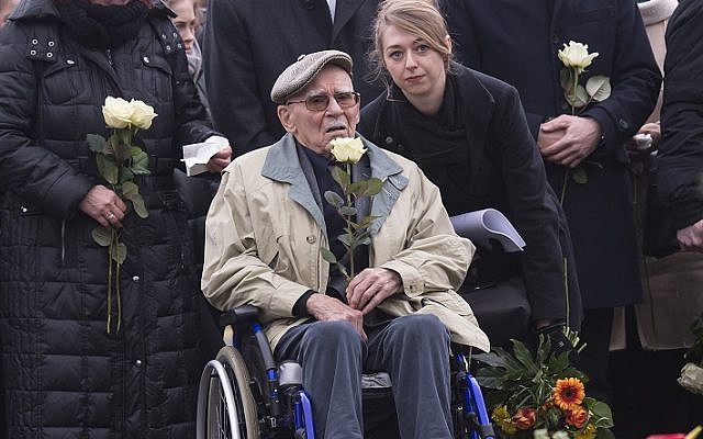 Former Nazi concentration camp survivor Raymond Renaud of France holds a white rose during the wreath-layin  ceremony on occasion of International Holocaust Remembrance Day in the former Nazi concentration camp Buchenwald near Weimar, Germany, Friday, Jan. 26, 2018. (AP Photo/Jens Meyer)