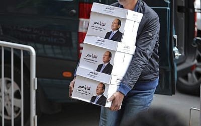In this undated file image released Wednesday, Jan. 24, 2018 on the official Facebook account of Egyptian President Abdel-Fattah el-Sissi, shows workers carrying boxes that bear the president's image and the phrase "long live Egypt!" in Cairo, Egypt. (Egyptian President's Facebook page via AP, File)