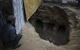A Palestinian man looks at a discovered tomb consisting of nine burial holes, which was found by Abdelkarim al-Kafarna, in his backyard in Beit Hanoun, northern Gaza City, Friday, January 26, 2018. (AP Photo/ Khalil Hamra)