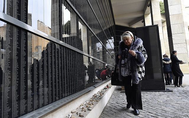 Illustrative: Hungarian Holocaust survivor, Katalin Sommer, lights a candle at the Victims' Memorial Wall bearing names of victims during a commemoration marking the International Holocaust Remembrance Day in the Holocaust Memorial Center in Budapest, Hungary, Friday, January 26, 2018, (Tibor Illyes/MTI via AP)