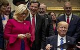 President Donald Trump gives his pen to Republican Congresswoman Liz Cheney, third from left, after signing one of various bills in the Roosevelt Room of the White House in Washington, Monday, March 27, 2017. (AP Photo/Andrew Harnik)