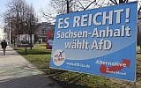 In this Wednesday, March 9, 2016 photo a man walks past a campaign poster of right-populist AfD party reading 'It's enough - Saxony-Anhalt elects AfD' in Magdeburg, Germany (AP Photo/Geir Moulson)