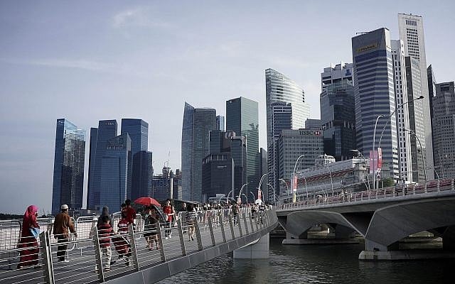 In this Aug. 8, 2015, photo, people walk on a bridge with the financial skyline of Singapore seen in the background, a day ahead of the nation's 50th year of independence. (AP Photo/Wong Maye-E) In this Aug. 8, 2015, photo, people walk on a bridge with the financial skyline of Singapore seen in the background, a day ahead of the nation's 50th year of independence. (AP Photo/Wong Maye-E)