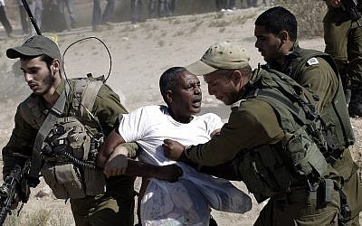 African migrants clash with Israeli soldiers after they left Holot detention center in southern Israel and walked towards the Border with Egypt near the southern Israeli Kibbutz of Nitzana, Friday, June, 27, 2014. (AP Photo/Tsafrir Abayov)