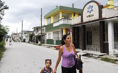 A woman and her young daughter walk past Comunidad Or Jadash, a synagogue serving the few Jews of Santa Clara. (Larry Luxner/Times of Israel)