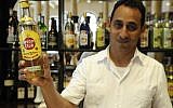 Illustrative: Wilbert Wilson Rivero, a Jewish bartender who works at Havana’s Hotel Raquel, proudly displays a bottle of Havana Club rum. (Larry Luxner/Times of Israel)